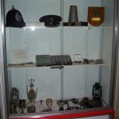 Photo:Exhibit in cell No.3 - Including Brighton constables helmet, superintendants cap, loud hailer, old Sussex buttons and badges, darts cup, and old paraffin lamps.