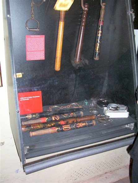 Photo:Display of "sticks" (truncheons) and hand-cuffs.