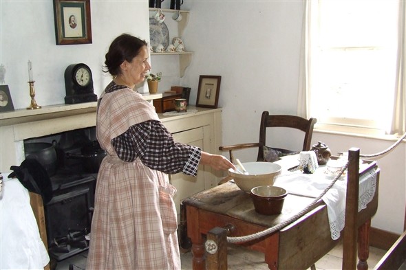 Photo:Interior of the left cottage with a cookery demonstration taking place